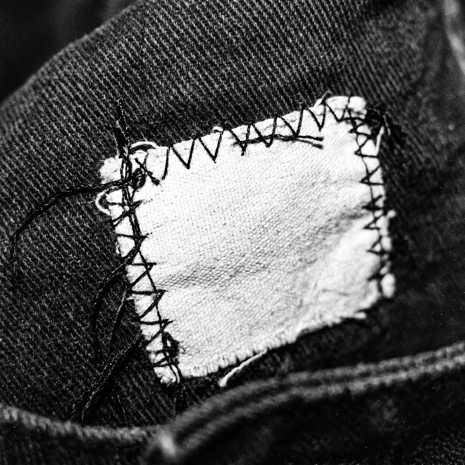 Extreme close-up of raw stitching and a woven garment label